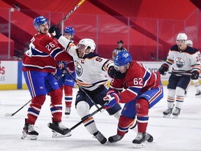 Edmonton Oilers forward Connor McDavid (97) attempts to go between Montreal Canadiens defenseman Jeff Petry (26) and teammate forward Artturi Lehkonen (62) during the first period at the Bell Centre.