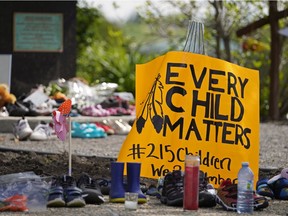 Hundreds of children's shoes remain in place at a memorial outside the Alberta legislature building in Edmonton on Monday, May 31, 2021. A vigil was held Sunday May 30, 2021 in memory of the 215 indigenous children whose remains were discovered on the grounds of a former Roman Catholic church residential school in Kamloops, B.C.