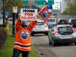 Edmonton Oilers fan Tanya Hamilton, an employee at United Sport and Cycle, gets into the playoff spirit outside the sporting goods store in Edmonton on Tuesday May 11, 2021. The store has set up an outdoor, drive through kiosk in the parking lot that is selling Edmonton Oilers paraphernalia from 7am to 11am until Friday May 14, 2021.