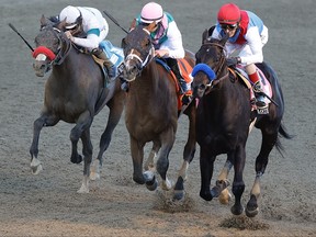 Medina Spirit, ridden by jockey John Velazquez, (right) crosses the finish line to win the 147th running of the Kentucky Derby ahead of Mandaloun, ridden by Florent Geroux, and Hot Rod Charlie ridden by Flavien Prat , at Churchill Downs on May 1, 2021 in Louisville, Ky.