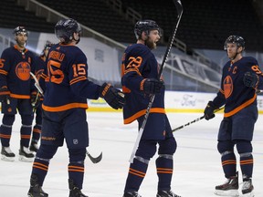 Edmonton Oilers Josh Archibald (15) celebrates his empty net goal with teammates Leon Draisaitl (29) and Connor McDavid (97) against the Calgary Flames during third period NHL action on Saturday, May 1, 2021 in Edmonton.