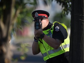 EPS Cst. Andrew Kirby uses laser radar at a speed trap set up on 99 Street in Edmonton in this Aug. 13, 2105 file photo.
