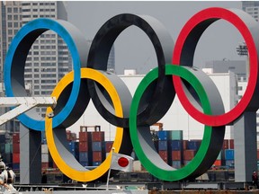 The giant Olympic rings are seen behind Japan's national flag amid the coronavirus disease (COVID-19) outbreak, at the waterfront area at Odaiba Marine Park in Tokyo, Japan August 6, 2020.