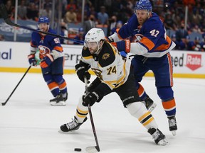 Boston Bruins left wing Jake DeBrusk (74) plays the puck against New York Islanders right wing Leo Komarov (47) during the third period of game six of the third round of the 2021 Stanley Cup Playoffs at Nassau Veterans Memorial Coliseum on June 9, 2021.