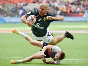 South Africa's (4) Zain Davids, dives over his Russian opponent for a try in HSBC Canada Men's Sevens action at BC Place Stadium in Vancouver, British Columbia on March 10, 2018.