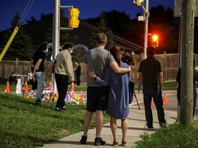 People and members of the media are seen at a makeshift memorial at the fatal crime scene where a man driving a pickup truck jumped the curb and ran over a Muslim family in what police say was a deliberately targeted anti-Islamic hate crime, in London, Ontario, Canada June 7, 2021.