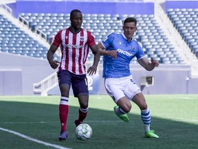FC Edmonton defender Amer Didic challenges Atletico Ottawa forward Malcolm Shaw for the ball in a Canadian Premier League match at Investors Group Field in Winnipeg, Man., on June 26, 2021.