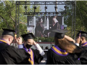 A graduation ceremony is projected on a giant screen during Archbishop MacDonald High School's drive-in graduation ceremony, at the Edmonton EXPO Centre parking lot Friday June 4, 2021. The unorthodox ceremony was in response to COVID-19 health restrictions.