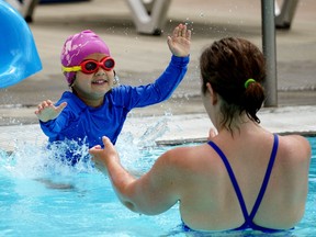 Cassidy Chugh (4) splashes into the arms of mom Charlotte McGinnis at Queen Elizabeth Outdoor Pool in Edmonton on Monday June 14, 2021, when the pool opened to the public. Pool goers have a time limit and must book ahead to be allowed admission into the facility. (PHOTO BY LARRY WONG/POSTMEDIA)