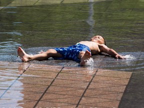 Ibrahim Khussanov ,5, tries to stay cool in the fountain in front of City Hall as temperatures rose to 29 C on Tuesday, June 22, 2021 in Edmonton.