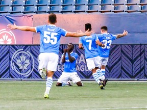 Jeannot Esua of FC Edmonton falls to his knees to celebrates his second-half goal against Forge FC at Investors Group Field in Winnipeg on July 21, 2021.