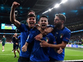 Jorginho of Italy celebrates with Matteo Pessina and Domenico Berardi after scoring their sides winning penalty in the penalty shoot out during the UEFA Euro 2020 Championship Semifinal match between Italy and Spain at Wembley Stadium on July 06, 2021 in London, England.