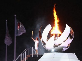 TOKYO, JAPAN - JULY 23: Naomi Osaka of Team Japan lights the Olympic cauldron with the Olympic torch during the Opening Ceremony of the Tokyo 2020 Olympic Games at Olympic Stadium on July 23, 2021 in Tokyo, Japan. (Photo by Matthias Hangst/Getty Images)