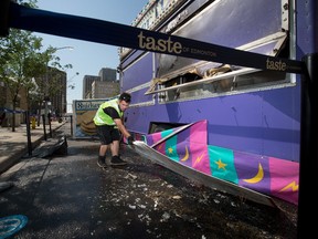 A Taste of Edmonton staff member clears away some of the fire damaged Snickerdoodle's booth in Sir Winston Churchill Square, Friday July 23, 2021. One person was taken to hospital after the Snickerdoodle’s trailer went up in flames on Thursday evening.