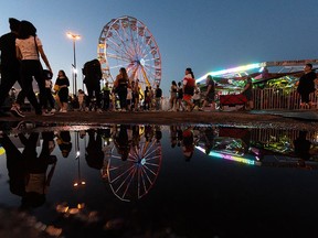 Fair fans attend the Summer Fun Midway outside of the Edmonton Expo Centre on Tuesday evening, July 27, 2021. Photo by Ian Kucerak