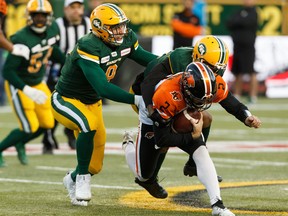 Edmonton Elks defensive end Mathieu Betts (9) helps haul down BC Lions quarterback Danny O'Brien (2) for a sack at Commonwealth Stadium in Edmonton on Oct. 12, 2019.