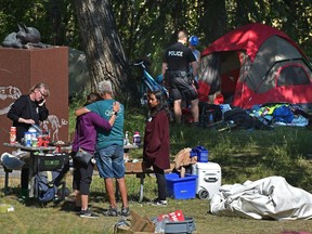 Police were on hand as a homeless support camp of about 20 people in Edmonton's Queen Elizabeth Park was cleared out by peace officers Friday morning.