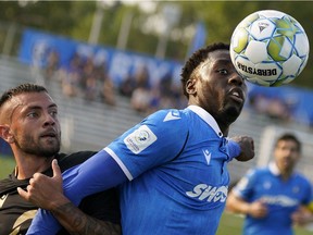 FC Edmonton's Mele Temguia, left. and Valour FC's Keven Aleman battle for the ball during Canadian Premier League soccer game action in Edmonton on Saturday, July 31, 2021.