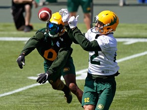 Defensive back Jonathan Rose (left) and receiver Greg Ellingson (right) reach for the ball during Edmonton Elks training camp at Commonwealth Stadium on Monday, July 12, 2021.