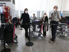 Passengers line up at Toronto Pearson International Airport on Monday, July 5, 2021.