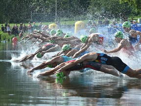 Competitors enter the water for the 750 metre swim course during the ITU World Triathlon at Hawrelak Park in Edmonton, July 20, 2019.