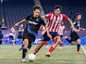 Paris Gee of FC Edmonton, left, plays the ball away from Rafael Nuñez Mata of Atlético Ottawa in a CPL contest at Investors Group Field in Winnipeg on July 18, 2021.