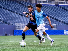 Kareem Sow of HFX Wanderers FC, right, and Easton Ongaro of FC Edmonton chase the ball down the pitch in a Canadian Premier League game at Investors Group Field in Winnipeg on July 21, 2021.