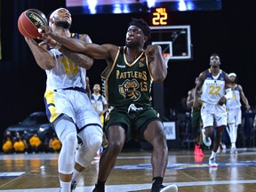 Edmonton Stingers Mathieu Kamba (10) gets fouled by Saskatchewan Rattlers Nervens Demosthene (13) at the Expo Centre in Edmonton on Thursday, July 8, 2021.