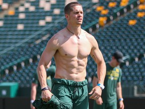 Edmonton Elks quarterback Trevor Harris loses a layer as the temperature topped 30 C at Commonwealth Stadium while training camp opened Saturday, July 10, 2021.
