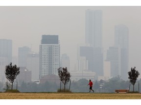 air, quality, warning Downtown Edmonton is obscured by wildfire smoke from British Columbia, as a jogger make their way through Forest Heights Park, in Edmonton Saturday July 17, 2021. Photo by David Bloom