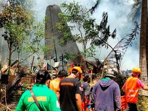 First responders work at the site after a Philippines Air Force Lockheed C-130 plane carrying troops crashed on landing in Patikul, Sulu province, Philippines July 4, 2021.