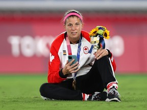 Stephanie Labbe of Team Canada poses with her gold medal while on the phone during the medal ceremony at the Tokyo 2020 Olympic Games at International Stadium Yokohama on Aug. 06, 2021, in Yokohama, Kanagawa, Japan.