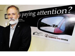 Dr. Louis Francescutti of the Coalition for Cellphone-Free Driving stands in front of a reminder poster.