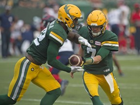 Quarterback Trevor Harris (7) of the Edmonton Elks, hands off to James Wilder Jr.  (32) against the Montreal Alouettes at Commonwealth Stadium on August 14, 2021. A report by TSN suggests this week's game in Toronto could be postponed by COVID protocols.