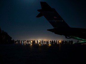 A U.S. Air Force aircrew, assigned to the 816th Expeditionary Airlift Squadron, prepares to load qualified evacuees aboard a U.S. Air Force C-17 Globemaster III aircraft in support of Afghanistan evacuation at Hamid Karzai International Airport, in Kabul, Afghanistan, Aug. 21, 2021.