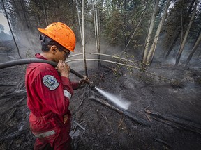 Private Seth Longjohn, a member of 1st Battalion, Princess Patricia's Canadian Light Infantry, sprays water in a burn zone, putting out hotspots in the area of Oliver, B.C., while deployed on Operation LENTUS, August 1, 2021. Credit: MS Dan Bard, Canadian Forces Combat Camera Canadian Forces Photo