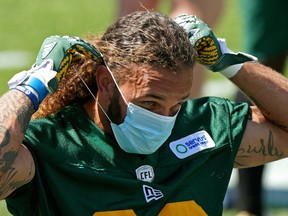 Defensive halfback Aaron Grymes puts on a face mask during Edmonton Elks training camp at Commonwealth Stadium on July 12, 2021. The team returned to the field Wednesday after serving a 10-day quarantine after 13 players tested positive for COVID-19.