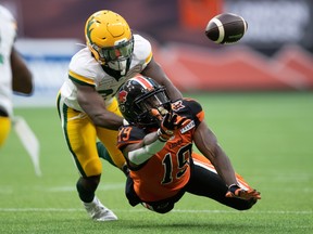 B.C. Lions' Dominique Rhymes (19) dives but fails to make the reception as Edmonton Elks linebacker Darius Williams defends in Vancouver on Thursday Aug. 19, 2021.