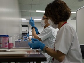 Medical staff prepare Moderna coronavirus vaccines for use at the newly-opened mass vaccination centre on May 24, 2021 in Tokyo.