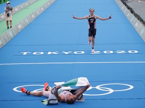 Gold medalist Kristian Blummenfelt, of Norway, and silver medalist Alex Yee, of Britain, reach the finish line at Odaiba Marine Park in the men's triathlon event of the Tokyo 2020 Olympics on July 26, 2021.