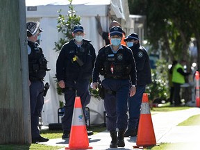Police walk outside a residential building in the southwestern Sydney suburb of Campbelltown on August 4, 2021.