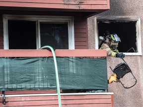 Firefighter remove debris from a suite in Commonwealth Place on 93 Street and 105a Ave. on August 3,  2021. Two occupants were rescued and sent to hospital for observation.