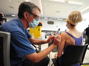 Dr. Ross McDonald gives a vaccination at the Vancouver Convention Centre on June 24, 2021.