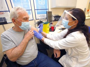 Shoppers Drug Mart pharmacist Anna Giroba gives a COVID-19 vaccine to Ivan Brown at the Evergreen Village location on Thursday, March 18, 2021. One community pharmacist in Airdrie is asking for more vaccine supply, saying his operation could vaccinate hundreds of people per day.