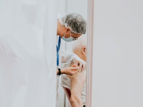 FILE: A healthcare worker gives a patient a shot.