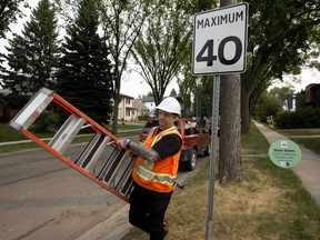 Crews clean up following a press conference about Edmonton's new 40 km/h speed limit for residential streets, Friday Aug. 6, 2021. =