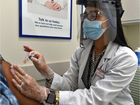 Shoppers Drug Mart pharmacist Shivali Sharma gives a flu shot to a patient in Edmonton, Thursday, Nov. 12, 2020.