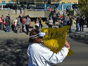 A group of people hold a rally against COVID-19 vaccinations in front of the Royal Alexandra Hospital on Monday, Sept. 13, 2021.