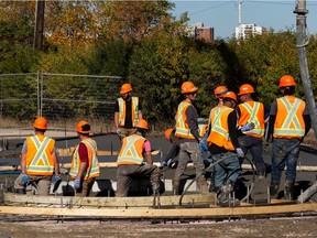 A construction crew pave the area where the historic Garneau Lamp was located at 109 Street and 88 Avenue in Edmonton, on Wednesday, Sept. 29, 2021.
