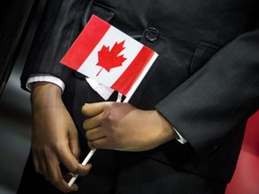 A young boy holds a flag during a citizenship ceremony in Otttawa in in this Jan. 18, 2020 file photo.